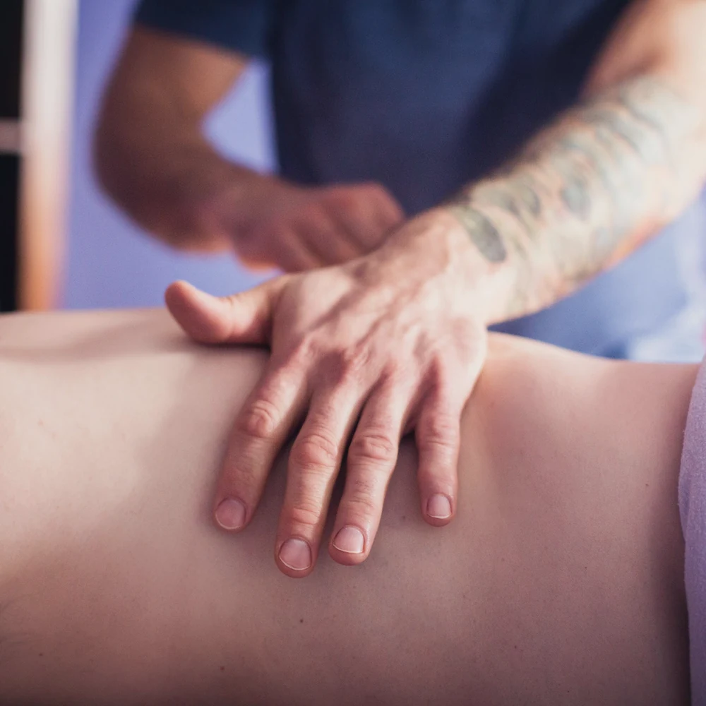 Dłonie terapeuty podczas masażu pleców